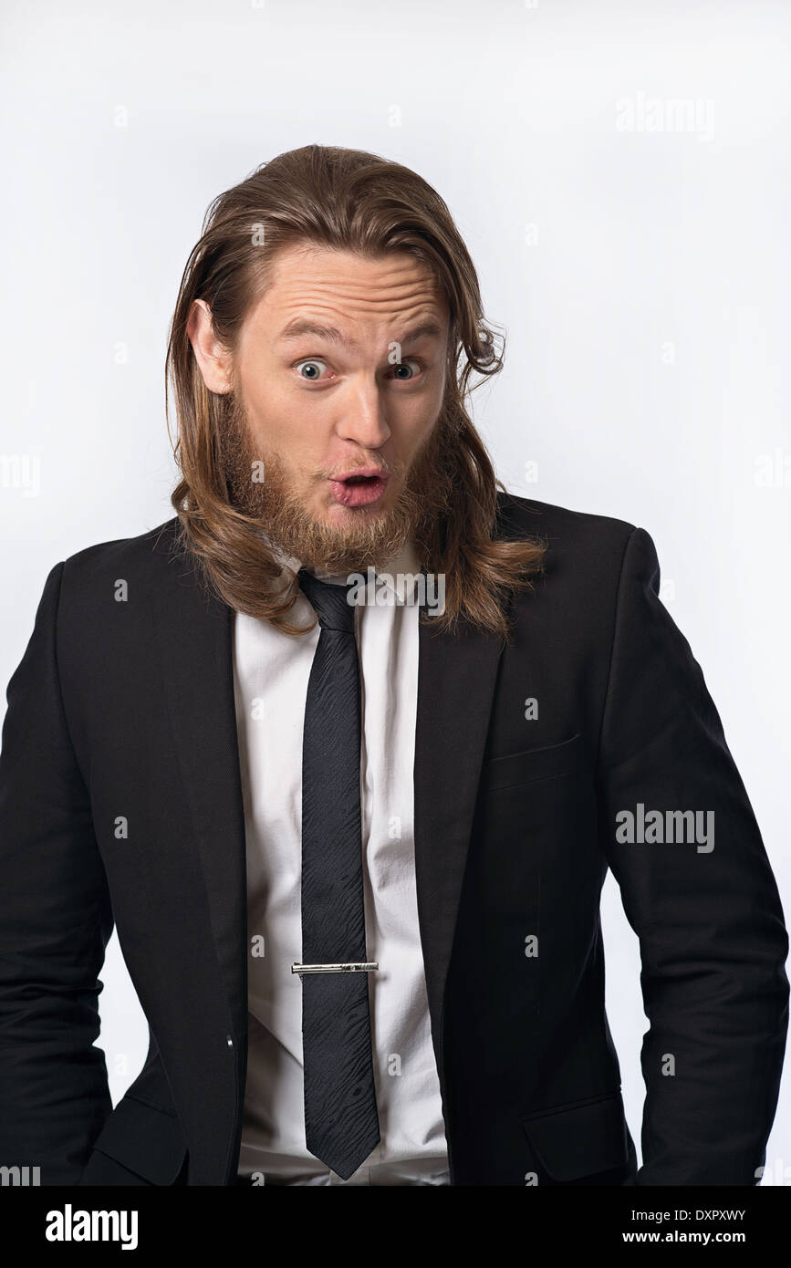 Un barbuto capelli lunghi uomo in tuta con espressione divertente. Un ritratto umoristico concept Foto Stock