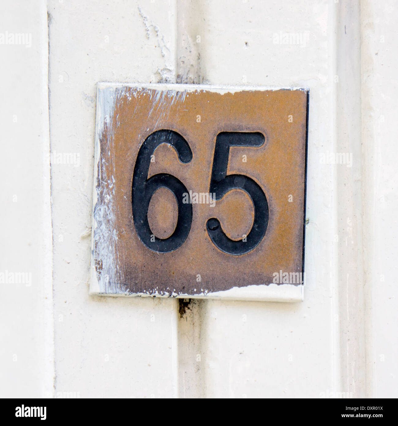 Numero di casa sessanta cinque incise in un marrone targa in ottone Foto Stock