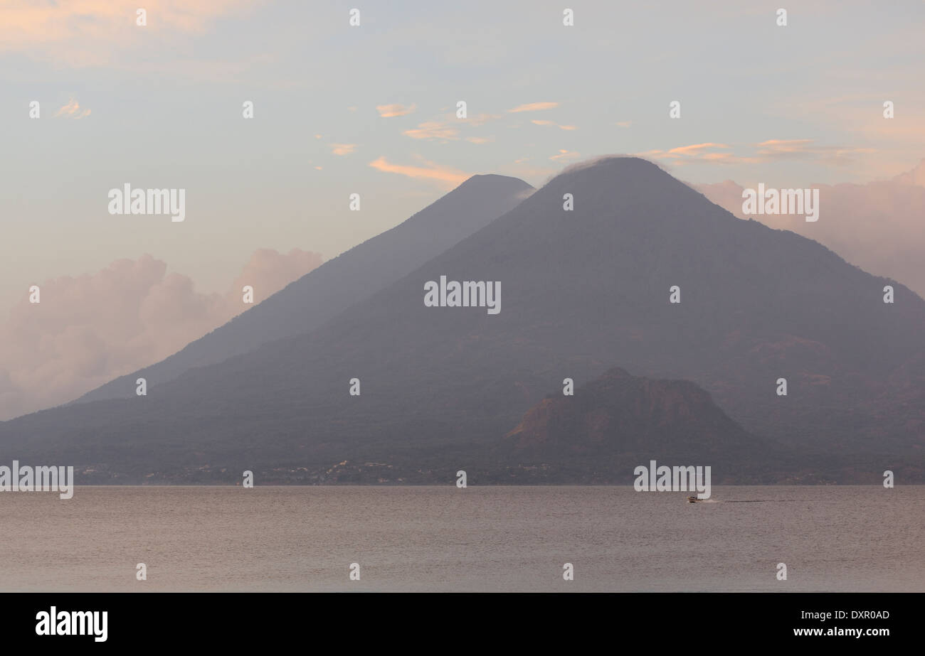 La mattina presto vista sul lago Atitlan da Panajachel. Una barca a motore passa davanti a Volcan Toliman, 3153m, Foto Stock