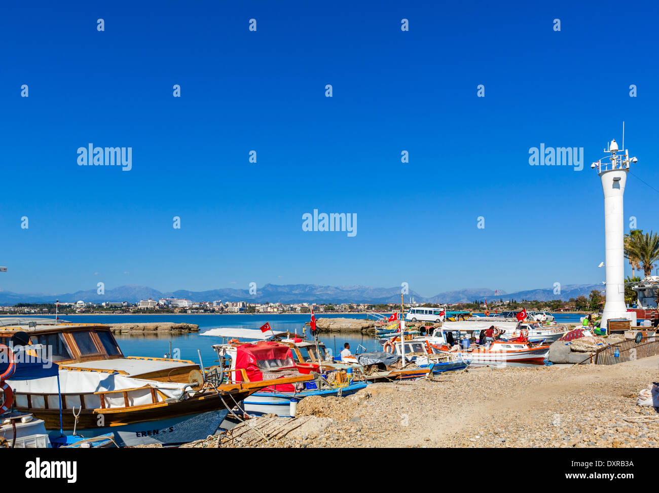 Barche da pesca nella città vecchia porto guardando verso le spiagge e hotel zona ad ovest della città, laterale, Provincia di Antalya, Turchia Foto Stock