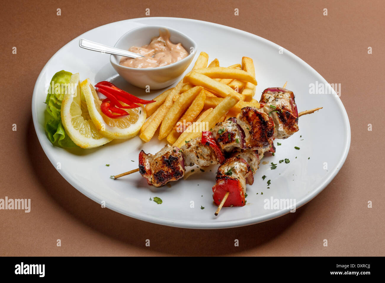 Grigliate di carne con patate fritte e salse Foto Stock