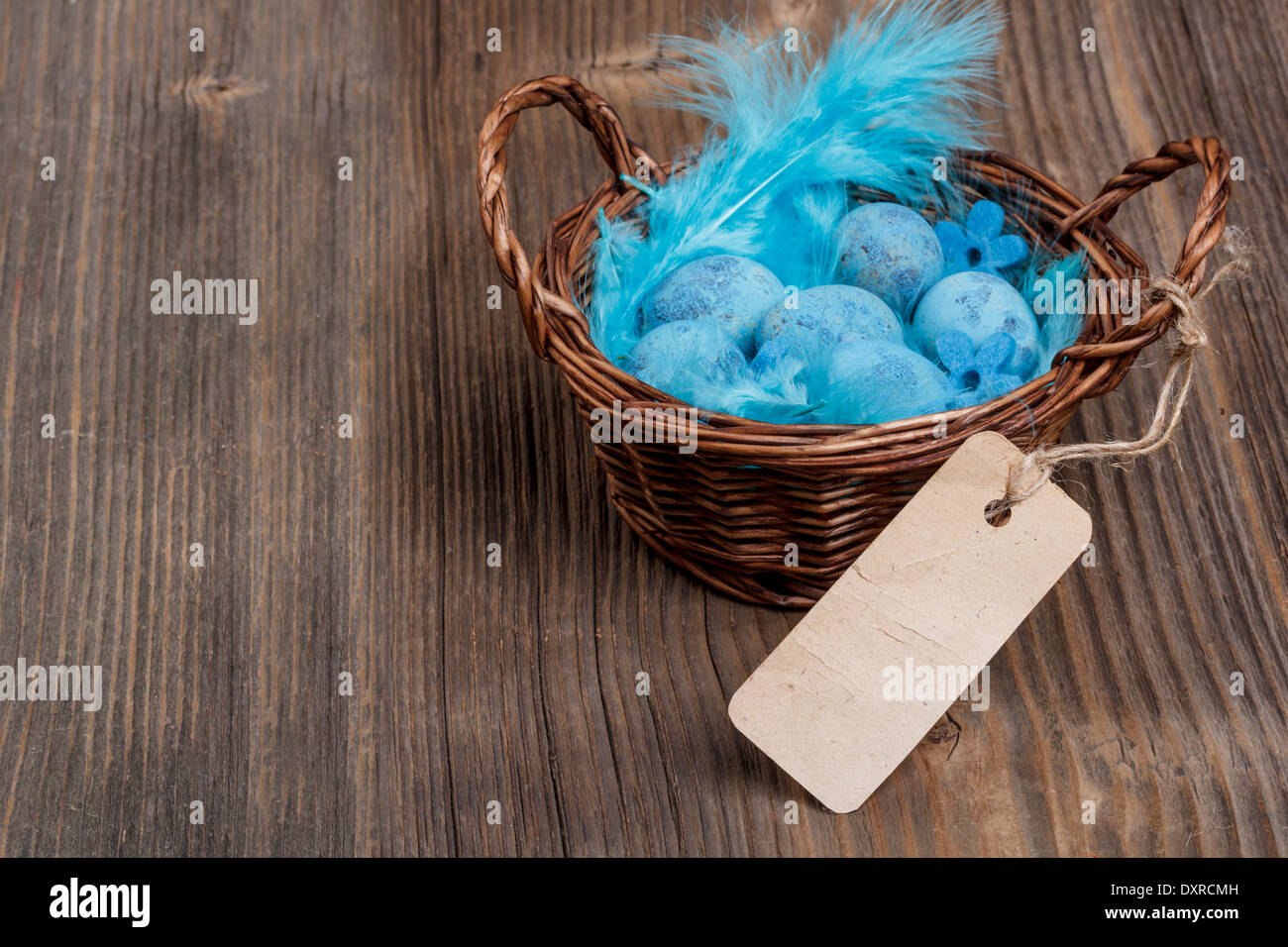 Cestello blu con uova di quaglia su sfondo di legno Foto Stock