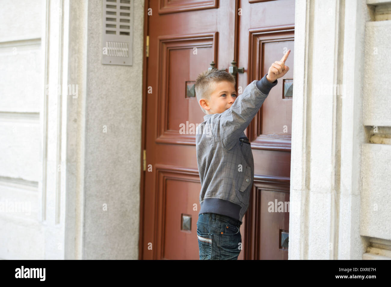 Giovane ragazzo squillo del campanello Foto Stock