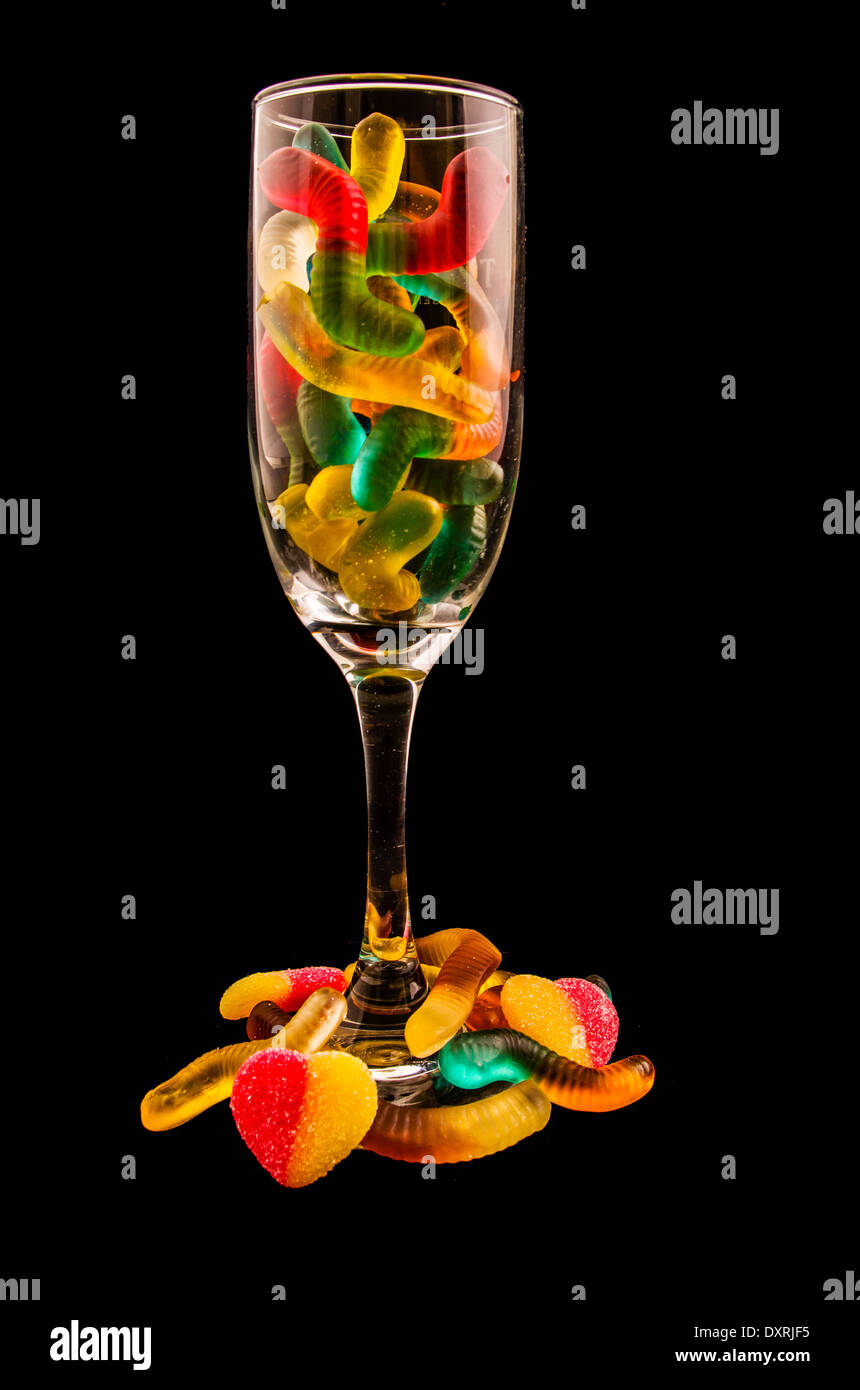Orsi gommoso e bicchiere di vino su uno sfondo scuro Foto Stock