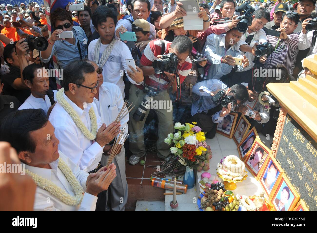 Phnom Penh Cambogia. 30 Mar, 2014. Sam Rainsy (2a L, anteriore), presidente dell'opposizione Nazionale cambogiana partito di salvataggio (CNRP), prega in Phnom Penh Cambogia, 30 marzo 2014. Il CNRP domenica mattina terrà una cerimonia religiosa in un memoriale di stupa in un parco, appena a sud del Palazzo Reale, in ricordo delle vittime di un attacco granata 17 anni fa. Credito: Li Hong/Xinhua/Alamy Live News Foto Stock