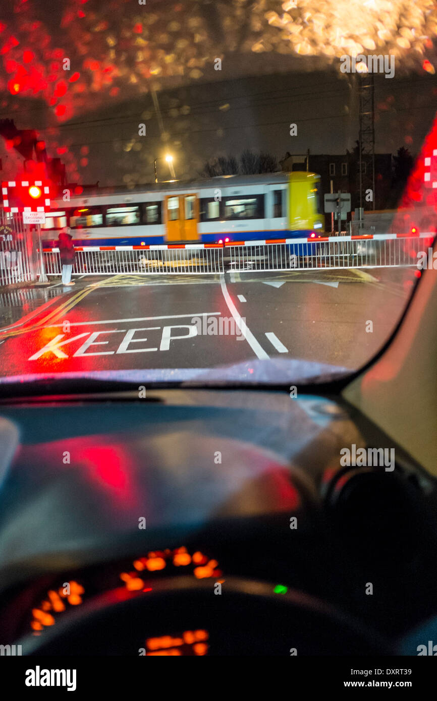 Auto in attesa al passaggio a livello di notte, REGNO UNITO Foto Stock