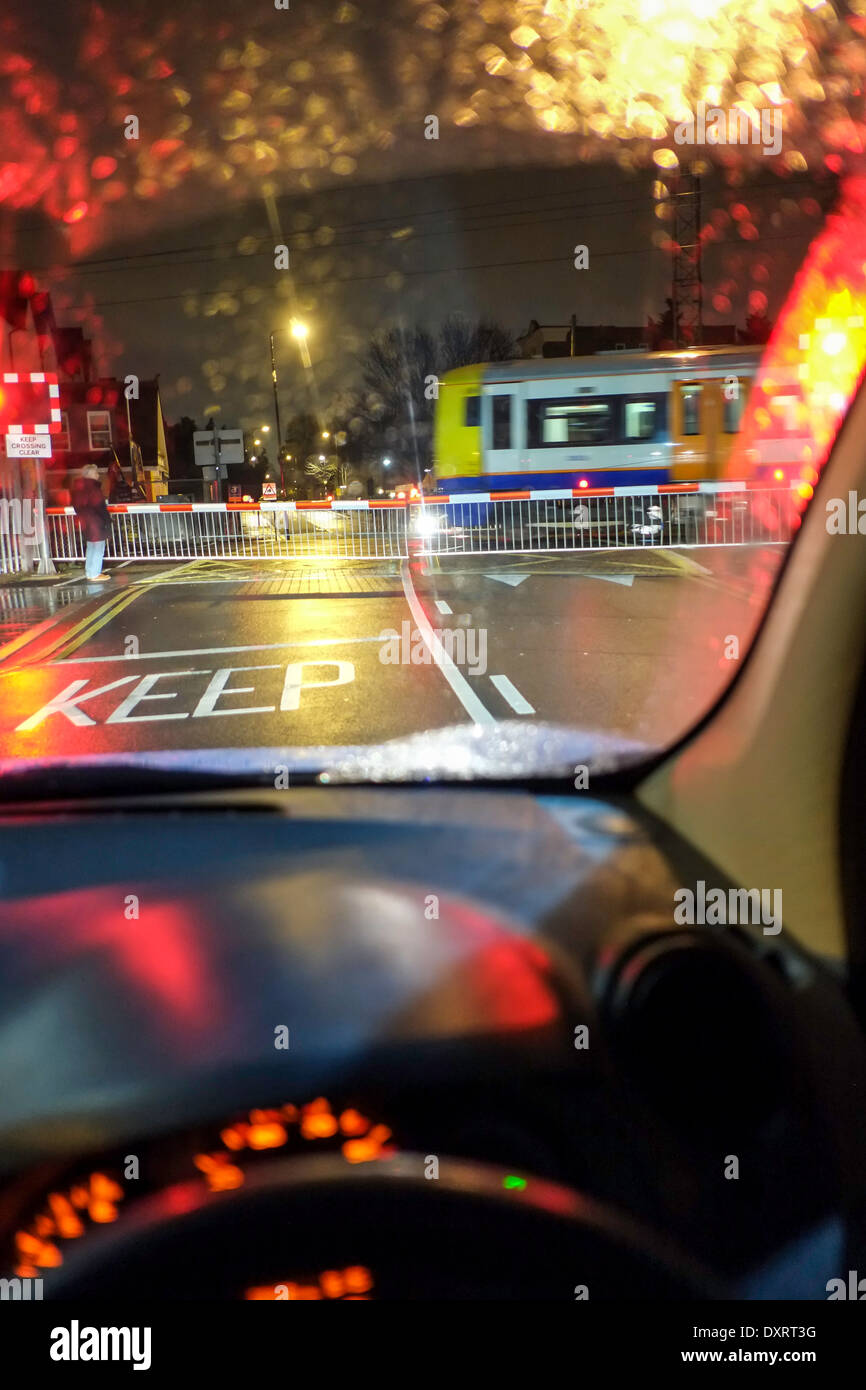 Auto in attesa al passaggio a livello di notte, REGNO UNITO Foto Stock