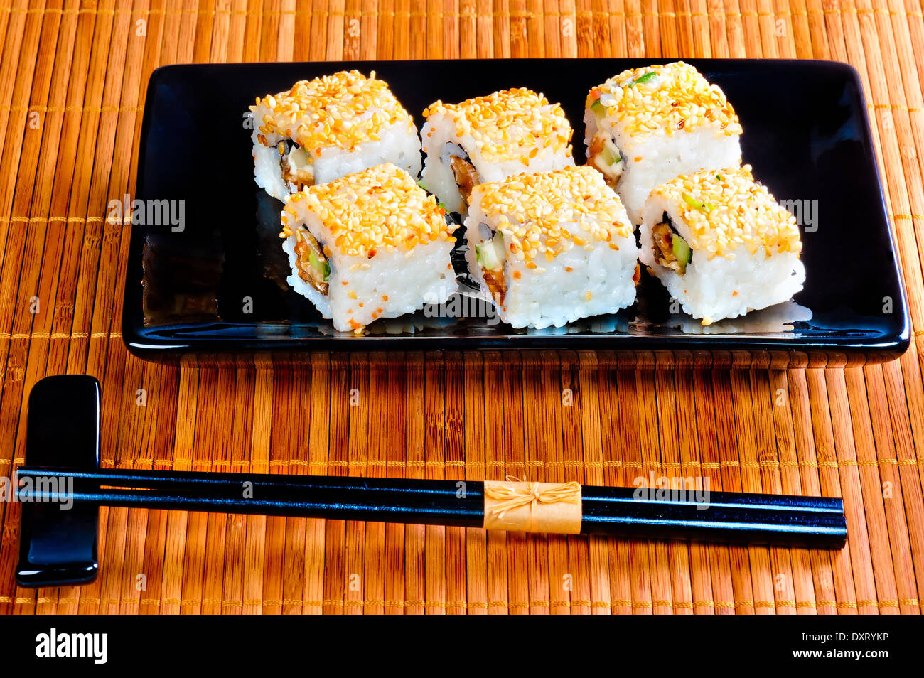 Rulli con anguilla e semi di sesamo su un bel piatto Foto Stock