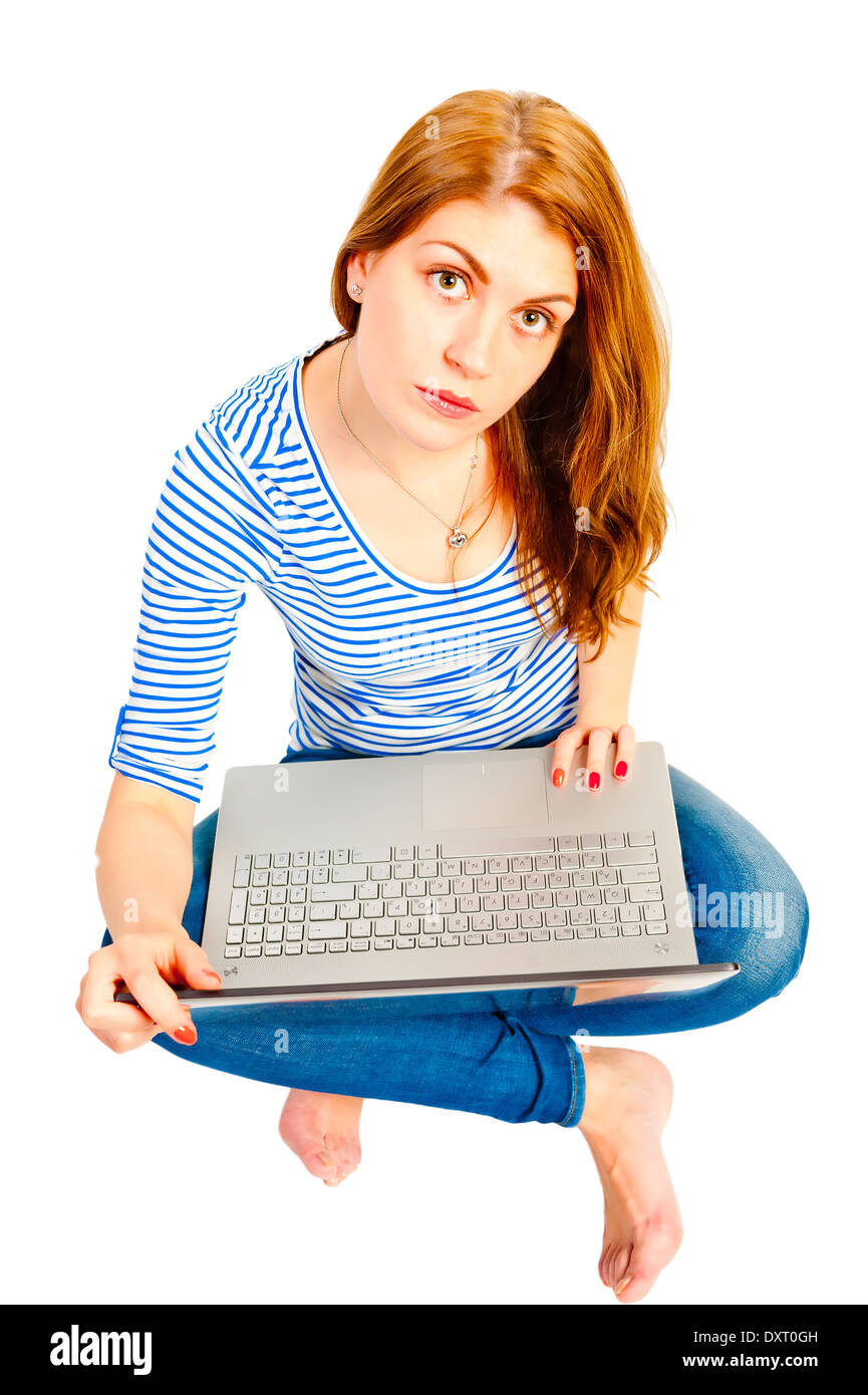 Un affascinante ragazza su uno sfondo bianco con un laptop Foto Stock