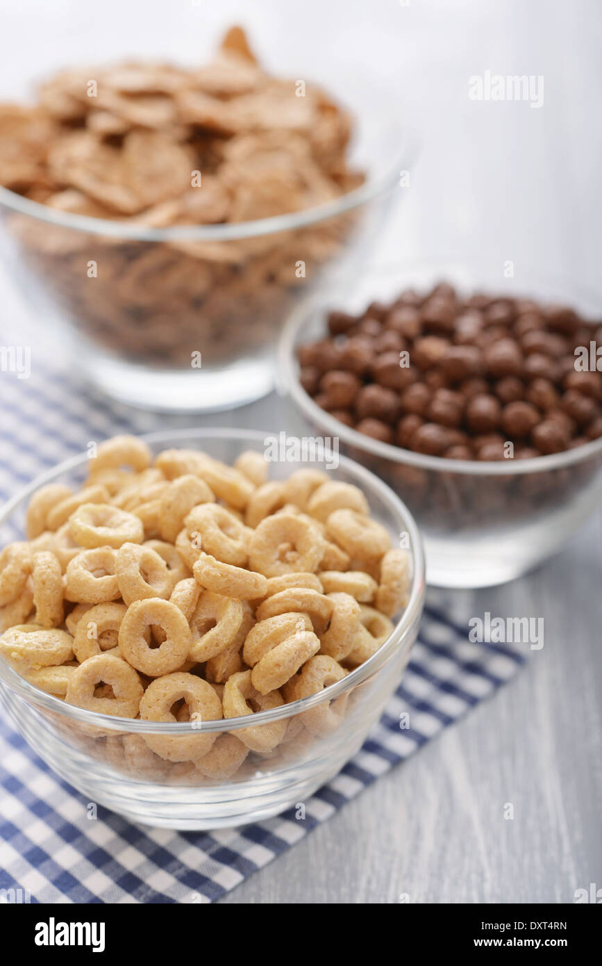Vari cereali da prima colazione in ciotole in vetro su sfondo in legno close-up Foto Stock