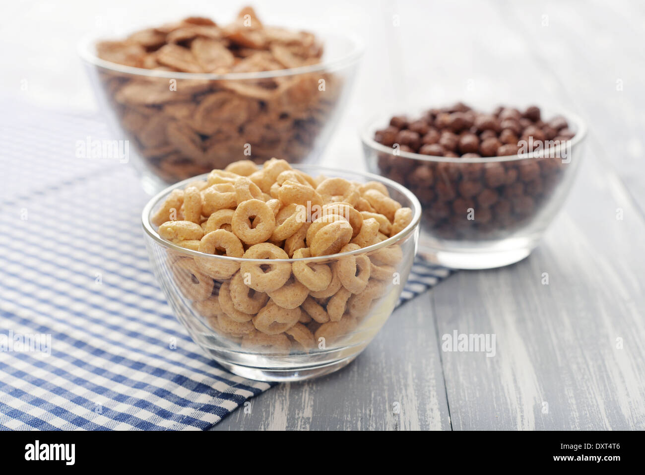 Vari cereali da prima colazione in ciotole in vetro su sfondo in legno close-up Foto Stock
