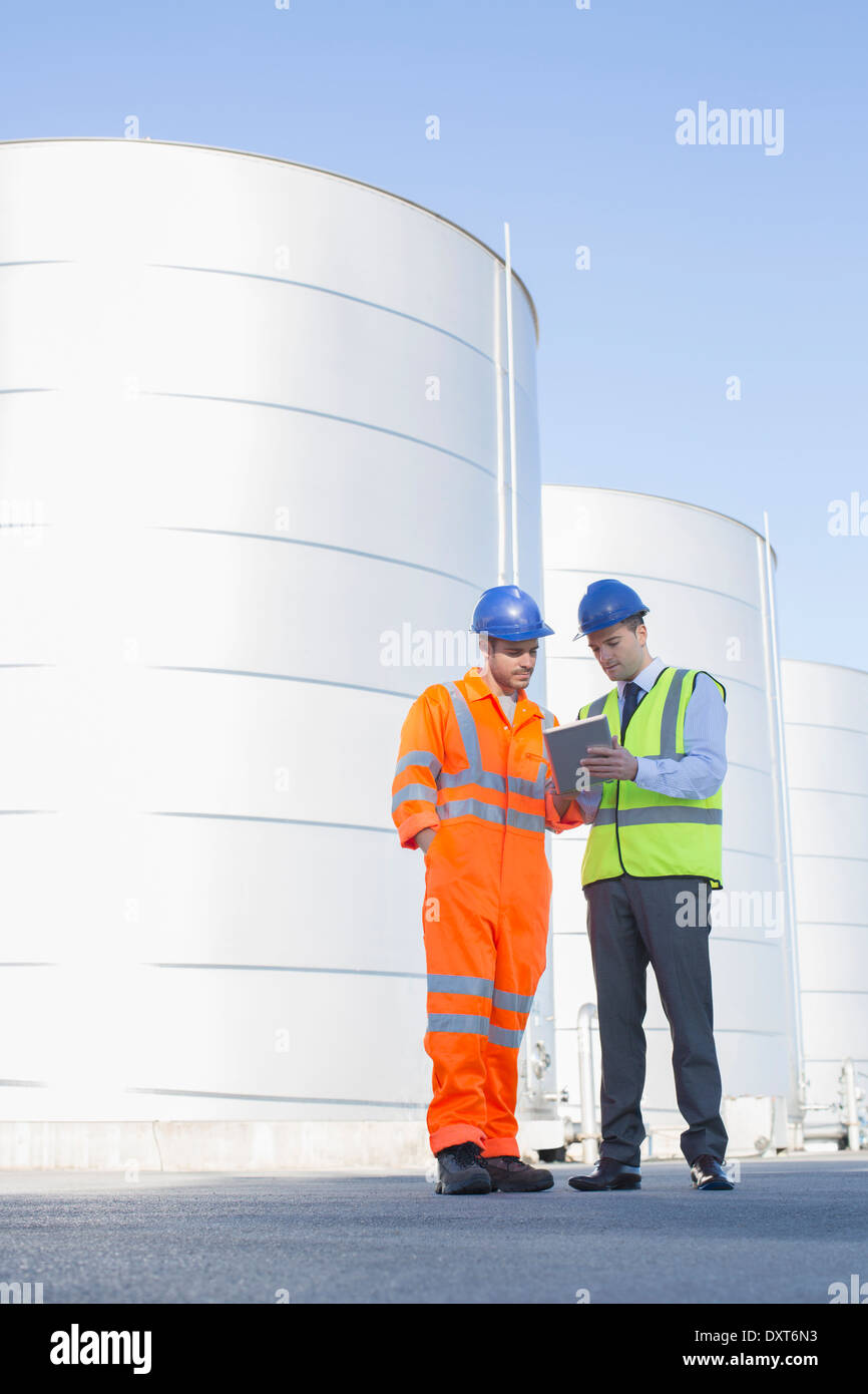 Imprenditore e lavoratore con tavoletta digitale accanto al foraggio insilato torri di storage Foto Stock