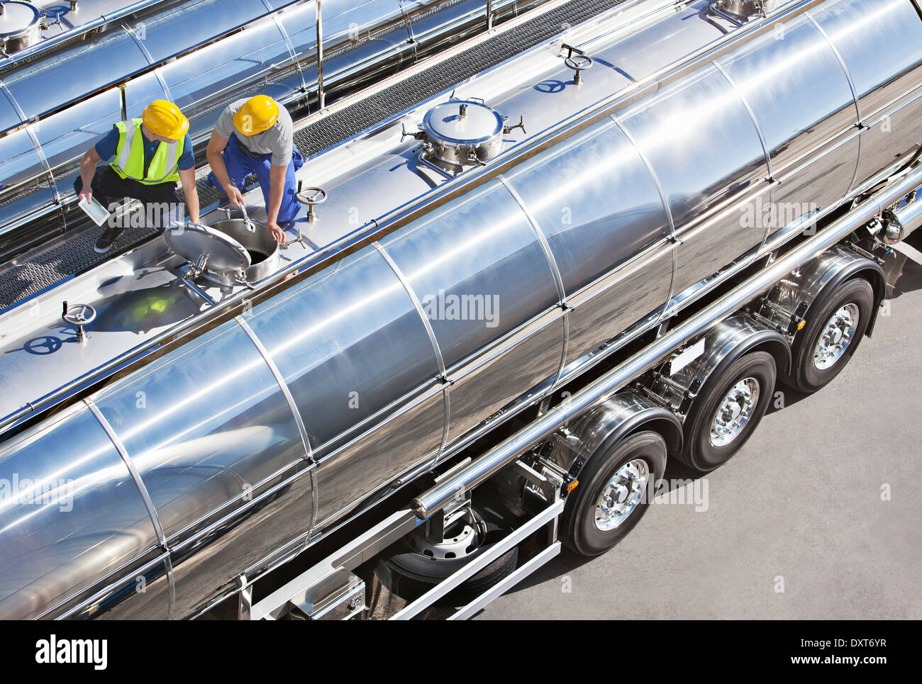 I lavoratori sulla parte superiore di acciaio inox autocisterna per il latte Foto Stock