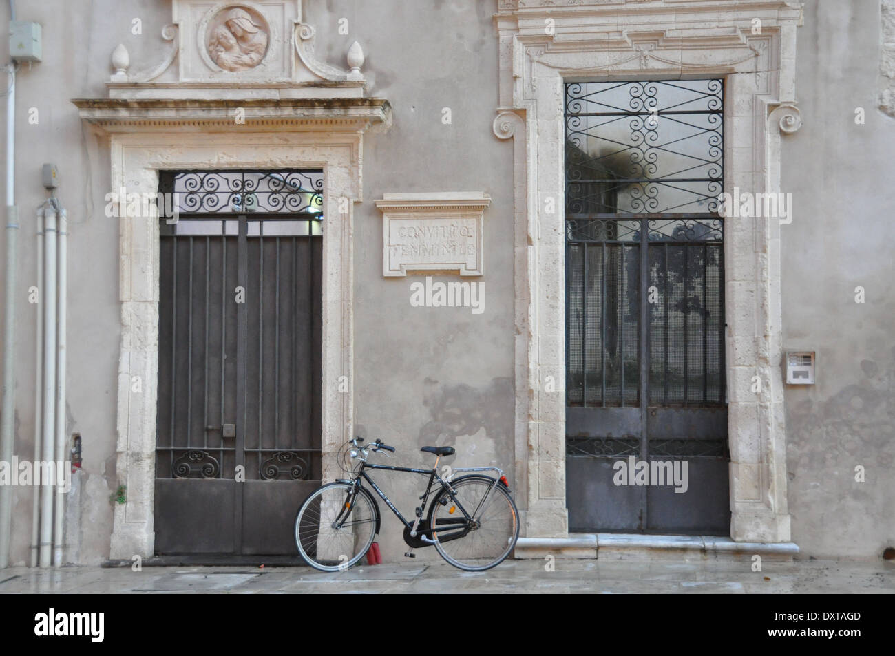 Una bicicletta tra due ingressi sincronizzato alla parte posteriore della Cattedrale di Siracusa, o Duomo di Siracusa. Foto Stock