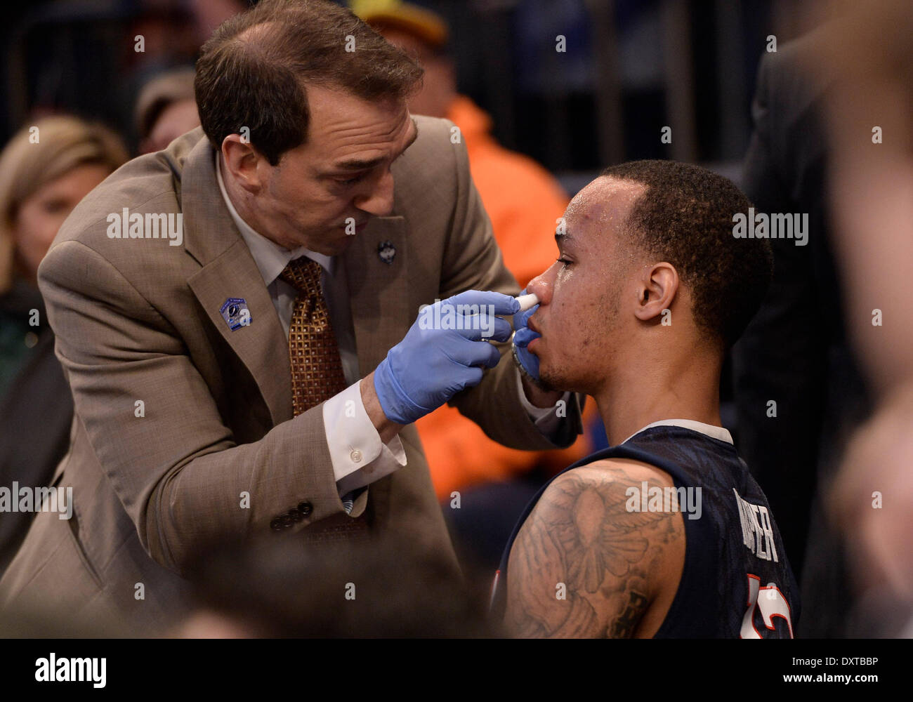 New York City, NY, STATI UNITI D'AMERICA. 30 Mar, 2014. Domenica 30 Marzo, 2014: UConn trainer James Doran dà Connecticut Huskies guard Shabazz Napier (13) primo aiuto a dopo essere stato colpito nel naso durante la seconda metà del torneo del NCAA Eastern Regional finale di partita di basket tra stati del Michigan e UConn al Madison Square Garden di New York, NY. UConn battere Michigan State 60-54 e anticipi per i quattro definitivi. Bill Shettle/Cal Sport Media. Credito: csm/Alamy Live News Foto Stock