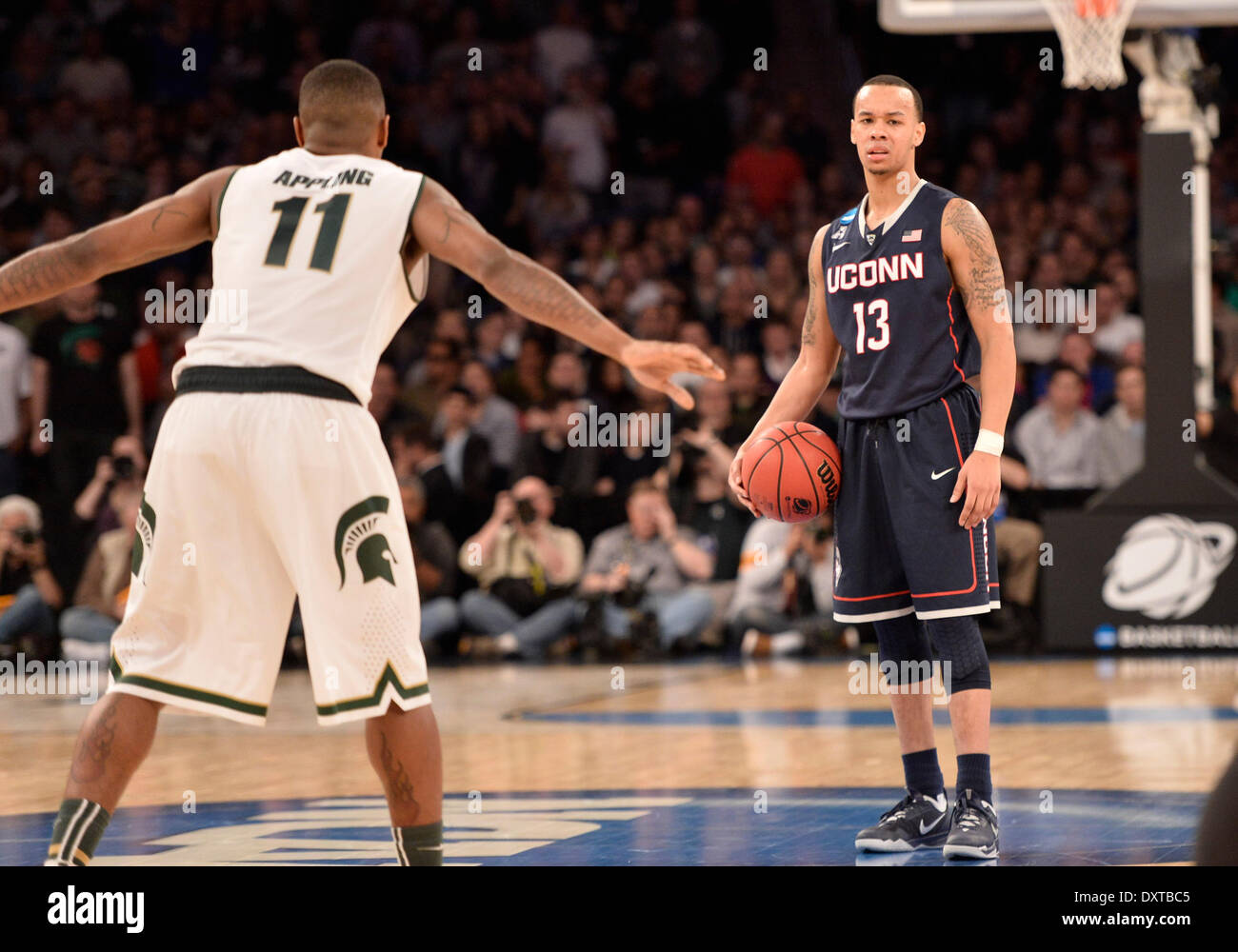 New York City, NY, STATI UNITI D'AMERICA. 30 Mar, 2014. Domenica 30 Marzo, 2014: Connecticut Huskies guard Shabazz Napier (13) trattenere la sfera con Michigan State Spartans guard Keith applicare (11) difendere molto tardi durante la seconda metà del torneo del NCAA Eastern Regional finale di partita di basket tra stati del Michigan e UConn al Madison Square Garden di New York, NY. UConn battere Michigan State 60-54 e anticipi per i quattro definitivi. Bill Shettle/Cal Sport Media. Credito: csm/Alamy Live News Foto Stock