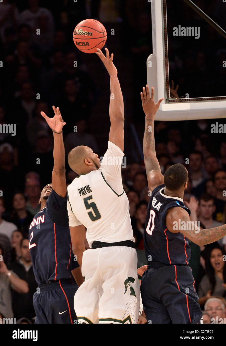 New York City, NY, STATI UNITI D'AMERICA. 30 Mar, 2014. Domenica 30 Marzo, 2014: Michigan State Spartans avanti Adreian Payne (5) passa per il cestello verso il basso contro il Connecticut Huskies avanti DeAndre Daniels (2) e Connecticut Huskies avanti Phillip Nolan (0) molto tardi durante la seconda metà del torneo del NCAA Eastern Regional finale di partita di basket tra stati del Michigan e UConn al Madison Square Garden di New York, NY. UConn battere Michigan State 60-54 e anticipi per i quattro definitivi. Bill Shettle/Cal Sport Media. Credito: csm/Alamy Live News Foto Stock