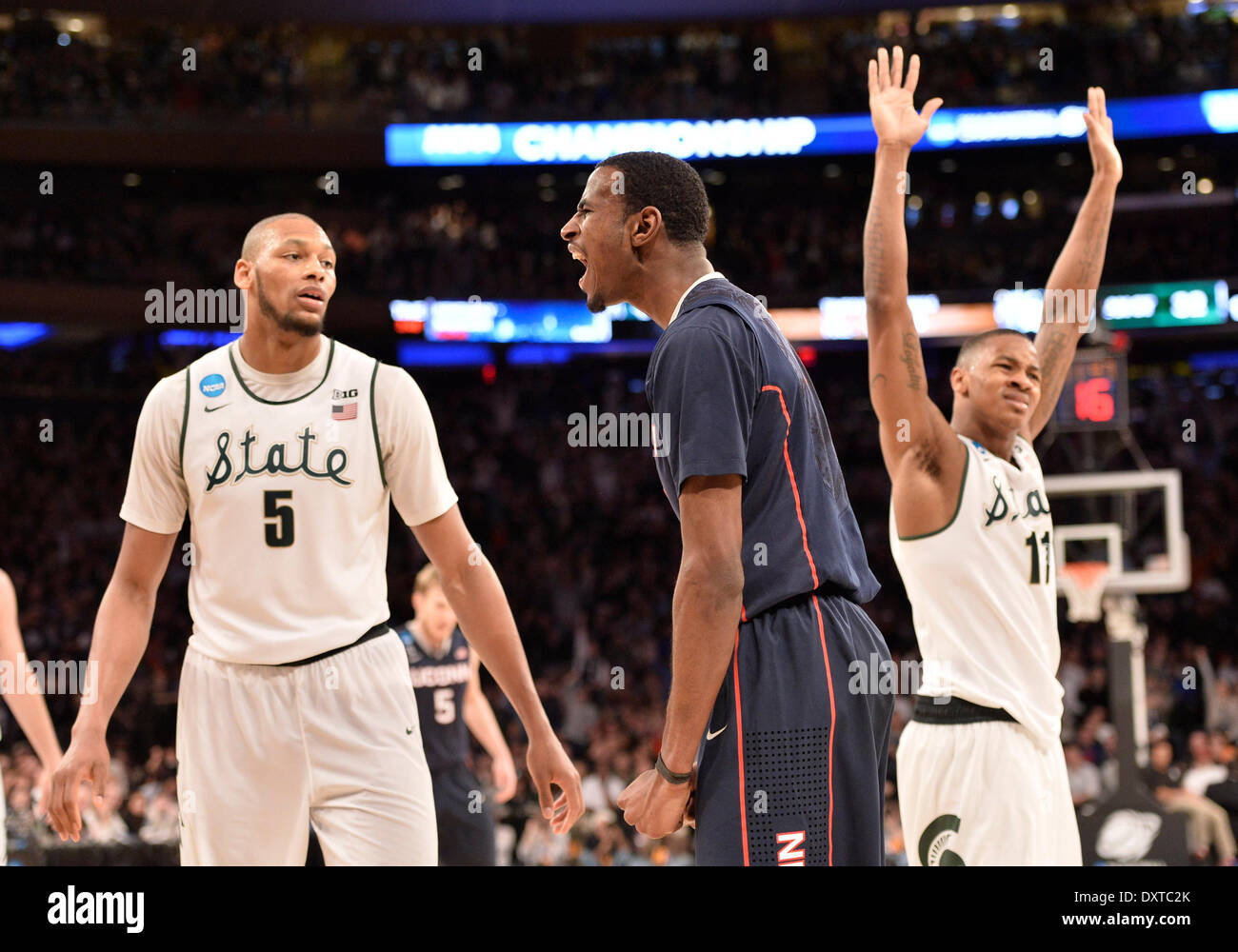 New York City, NY, STATI UNITI D'AMERICA. 30 Mar, 2014. Domenica 30 Marzo, 2014: Connecticut Huskies avanti DeAndre Daniels (2) celebra facendo un cestello e Michigan State Spartans guard Keith applicare (11) lamenta la chiamata e Michigan State Spartans avanti Adreian Payne (5) si affaccia su durante la seconda metà del torneo del NCAA Eastern Regional finale di partita di basket tra stati del Michigan e UConn al Madison Square Garden di New York, NY. UConn battere Michigan State 60-54 e anticipi per i quattro definitivi. Bill Shettle/Cal Sport Media. Credito: csm/Alamy Live News Foto Stock