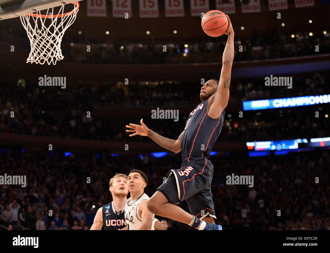New York City, NY, STATI UNITI D'AMERICA. 30 Mar, 2014. Domenica 30 Marzo, 2014: Connecticut Huskies avanti Phillip Nolan (0) schiacciate la sfera con Connecticut Huskies avanti Niels Giffey (5) e Michigan State Spartans guard Travis Trice (20) guarda sul molto tardi durante la seconda metà del torneo del NCAA Eastern Regional finale di partita di basket tra stati del Michigan e UConn al Madison Square Garden di New York, NY. UConn battere Michigan State 60-54 e anticipi per i quattro definitivi. Bill Shettle/Cal Sport Media. Credito: csm/Alamy Live News Foto Stock