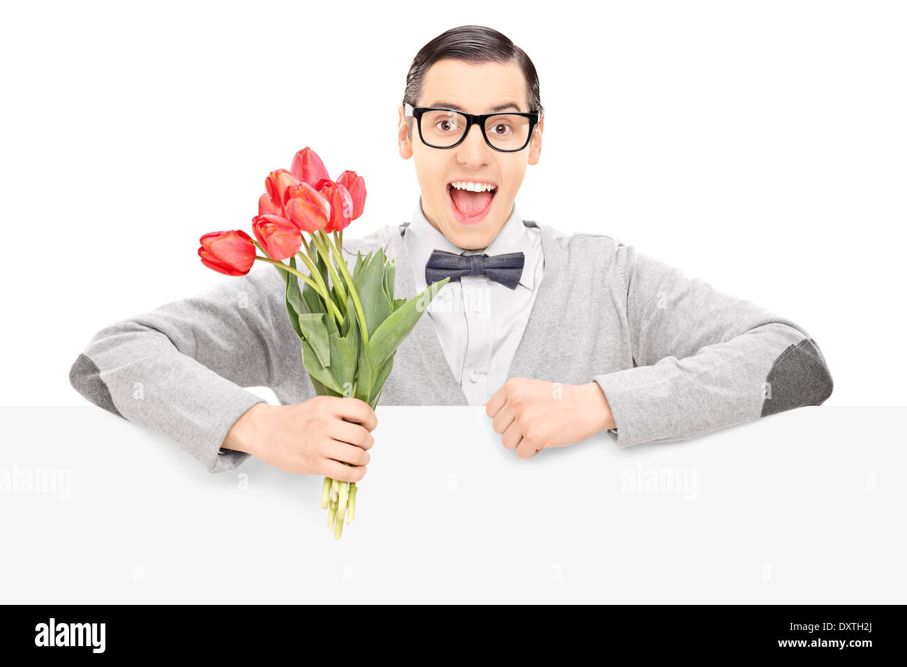 Maschio felice tenendo un mazzo di fiori dietro un pannello vuoto Foto Stock