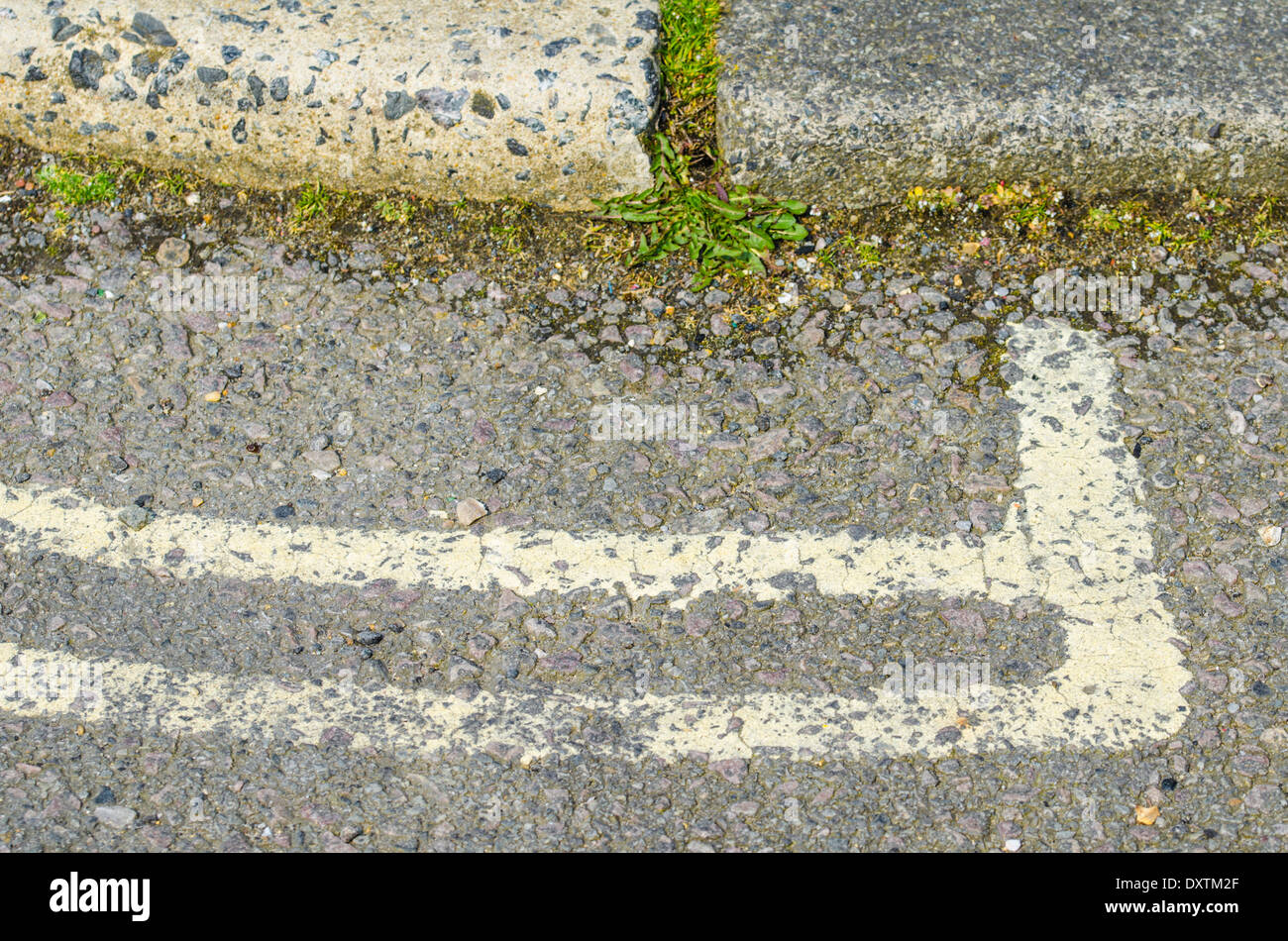 Doppie linee di colore giallo che termina su una strada in corrispondenza del cordolo. Foto Stock