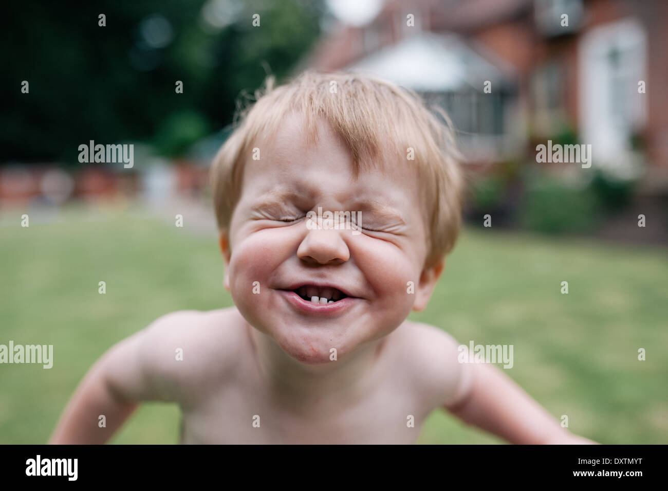 Un bimbo a faccia felice giocare in giardino in estate Foto Stock