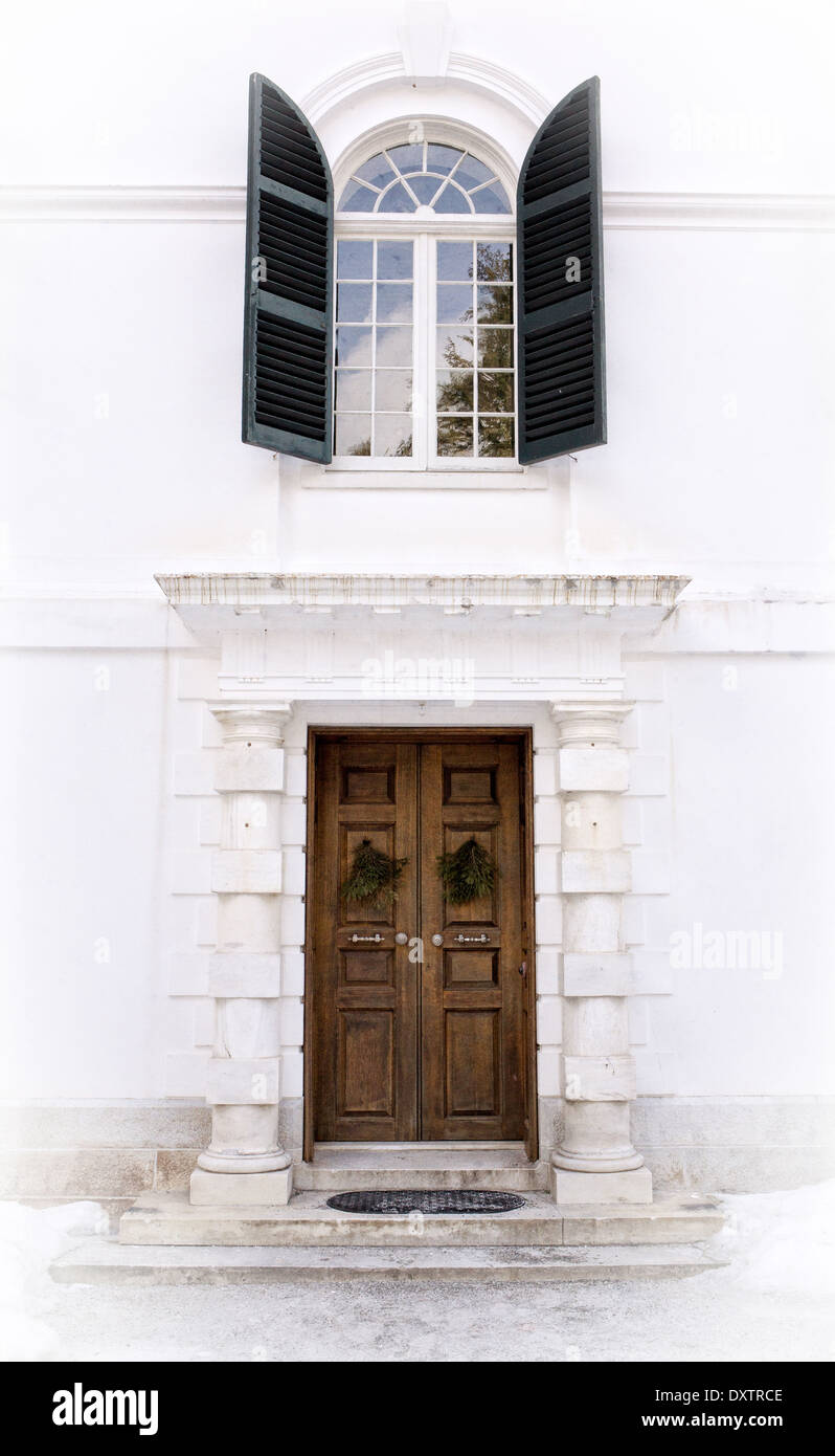 Ingresso ornato da un formale età dorata mansion con finestra ad arco e persiane di cui sopra. Foto Stock