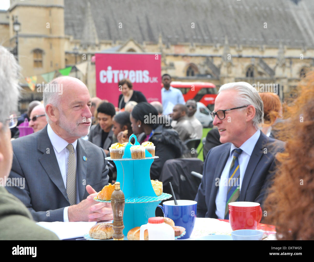 La piazza del Parlamento, Londra, Regno Unito. Il 31 marzo 2014. Norman Lamb MP (a destra) il Ministro di Stato per la cura e il supporto si siede ad un tavolo gustando il tè e dolci in piazza del Parlamento a un evento in cui, "oggi (lunedì 31 marzo), uno del Regno Unito più stabilito le associazioni di beneficenza che offrono assistenza e alloggio per gli anziani, la società Abbeyfield, firmato fino ai cittadini del Regno Unito la cura sociale Carta e ha accettato di pagare il loro personale i salari.' Credit: Matteo Chattle/Alamy Live News Foto Stock