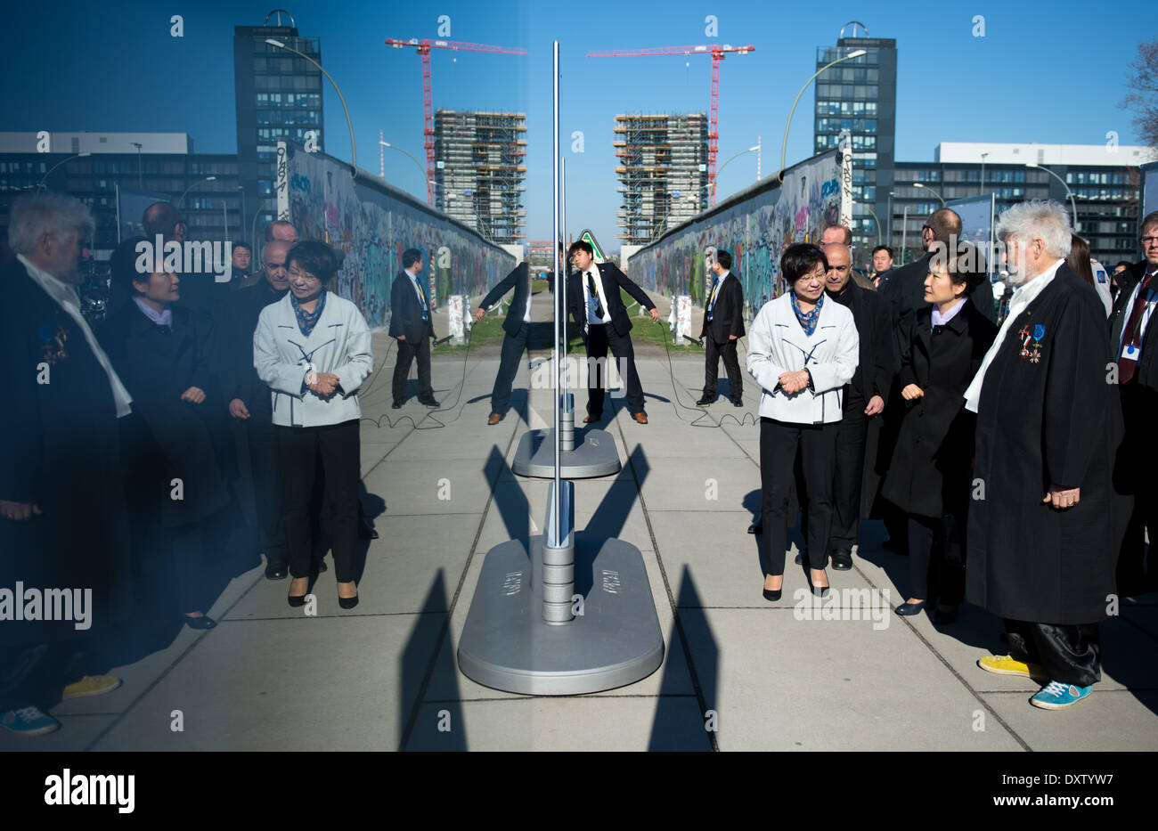 Il Presidente sud coreano Park Geun-hye (2-R) visite la East Side Gallery e una mostra fotografica sulla De-militarized zone tra Corea del Nord e Corea del sud di Berlino, Germania, 27 marzo 2014. Park è condotto attraverso la mostra fotografica dal direttore del coreano il Museo Nazionale di Arte Moderna, Choi Eunju (L), e l'artista di Berlino Achim Freyer (R). La più lunga ancora restante parte dell'ex interno-confine tedesco è stato di particolare interesse per il parco in quanto essa proviene da una nazione divisa se stessa. Foto: Bernd von Jutrczenka/dpa (riflessione causata da un salone del vetro a parete) Foto Stock