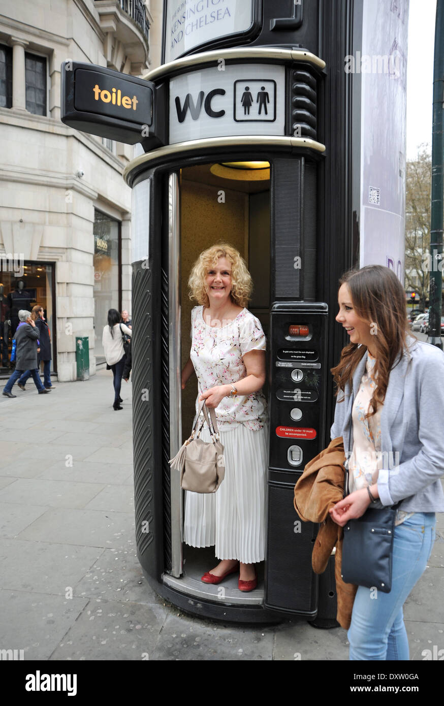 Donna emergente da servizi igienici pubblici box in Sloane Square London REGNO UNITO Foto Stock