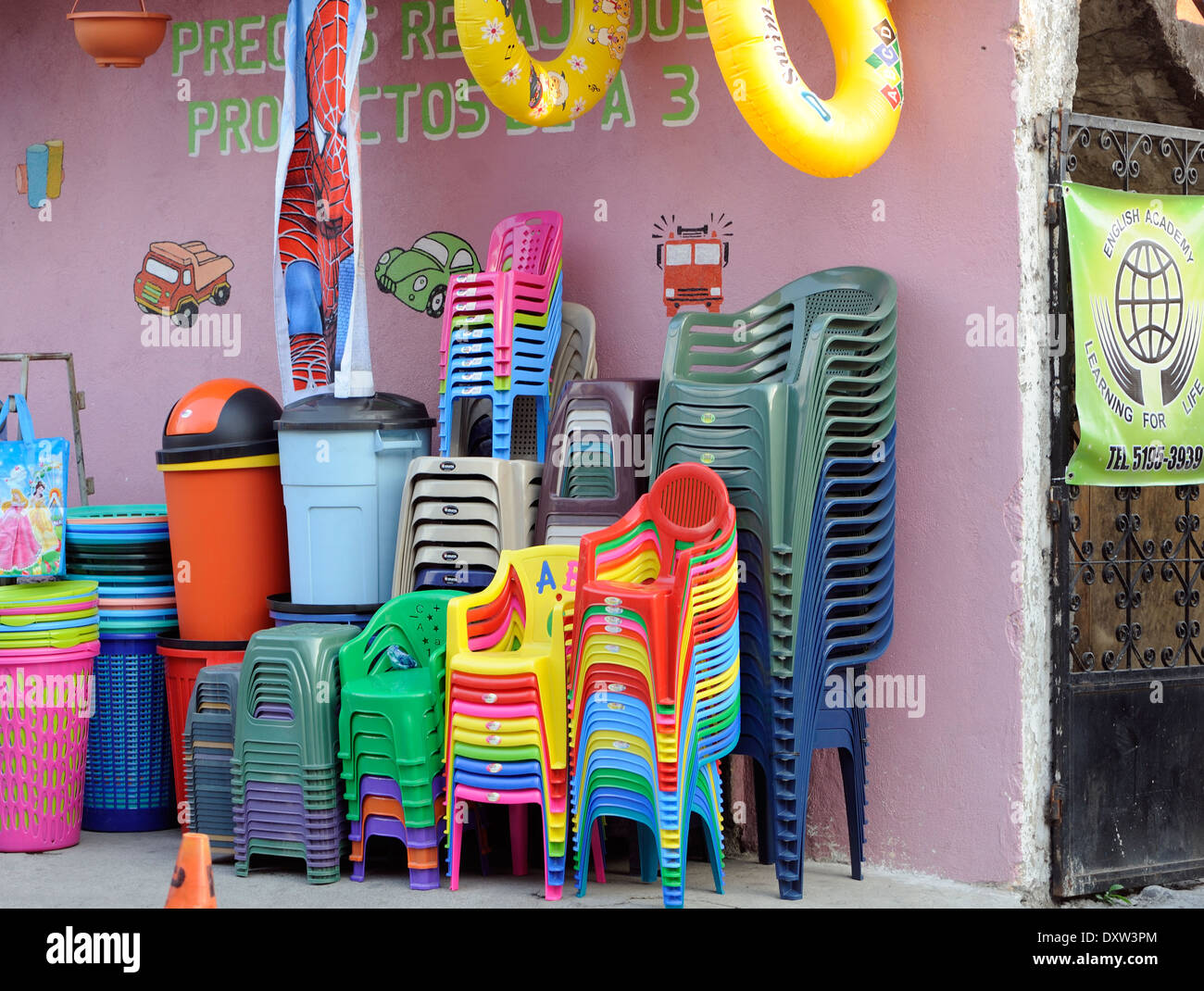Sedie di plastica e contenitori per la vendita al di fuori di un negozio. Panajachel, Repubblica del Guatemala. Foto Stock