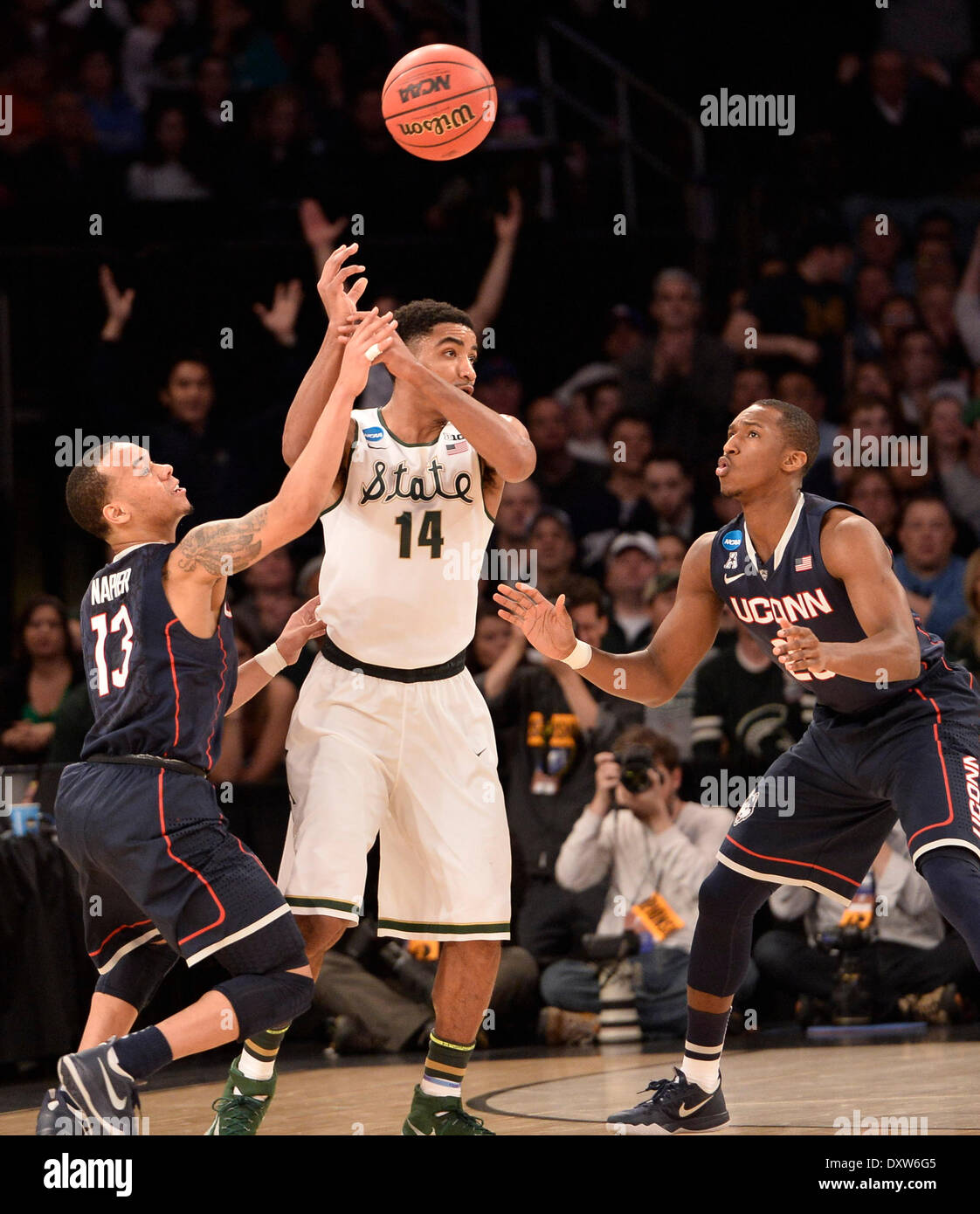 New York City, NY, STATI UNITI D'AMERICA. 30 Mar, 2014. Domenica 30 Marzo, 2014: Connecticut Huskies guard Shabazz Napier (13) batte la palla fuori del Michigan State Spartans guard Gary Harris (14) mani come Connecticut Huskies guard-avanti Lasan Kromah (20) si affaccia su durante la seconda metà del torneo del NCAA Eastern Regional finale di partita di basket tra stati del Michigan e UConn al Madison Square Garden di New York, NY. UConn battere Michigan State 60-54 e anticipi per i quattro definitivi. Bill Shettle/Cal Sport Media. © csm/Alamy Live News Foto Stock