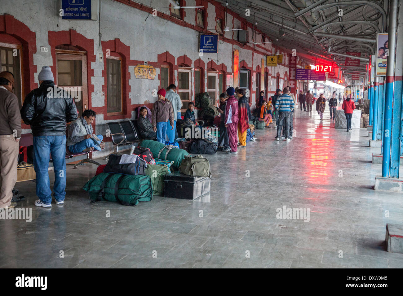 India, Dehradun. I passeggeri in attesa su piattaforma alla stazione ferroviaria. Foto Stock