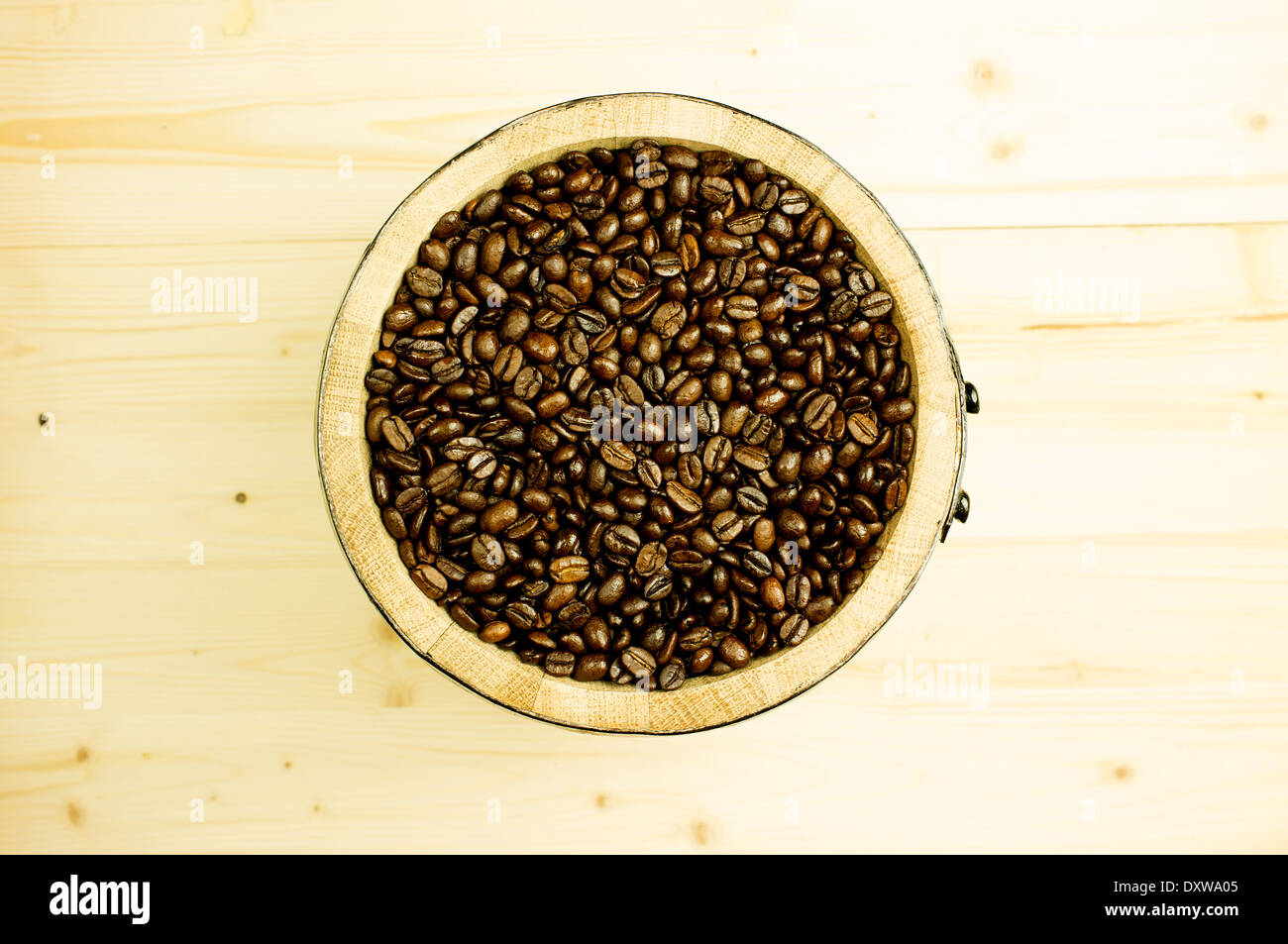 I chicchi di caffè in un barile di legno. Sfondo di legno Foto Stock