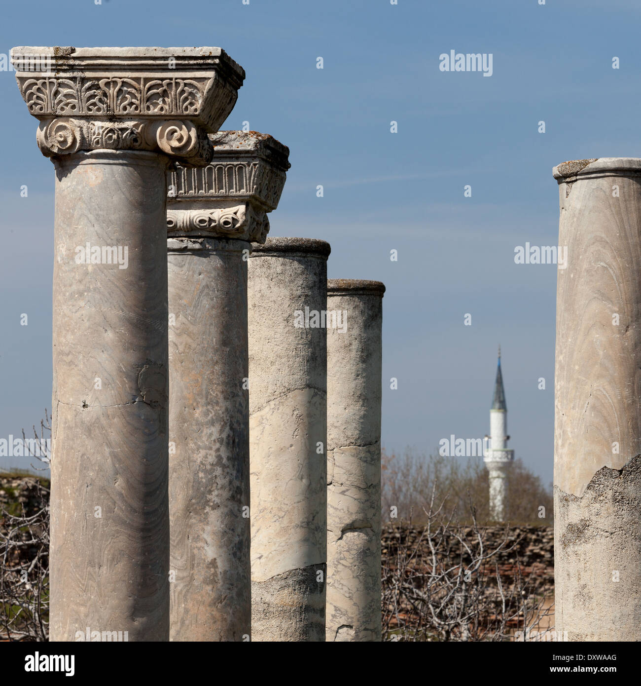 Minareto della moschea turca visto attraverso le colonne di un tempio greco Foto Stock