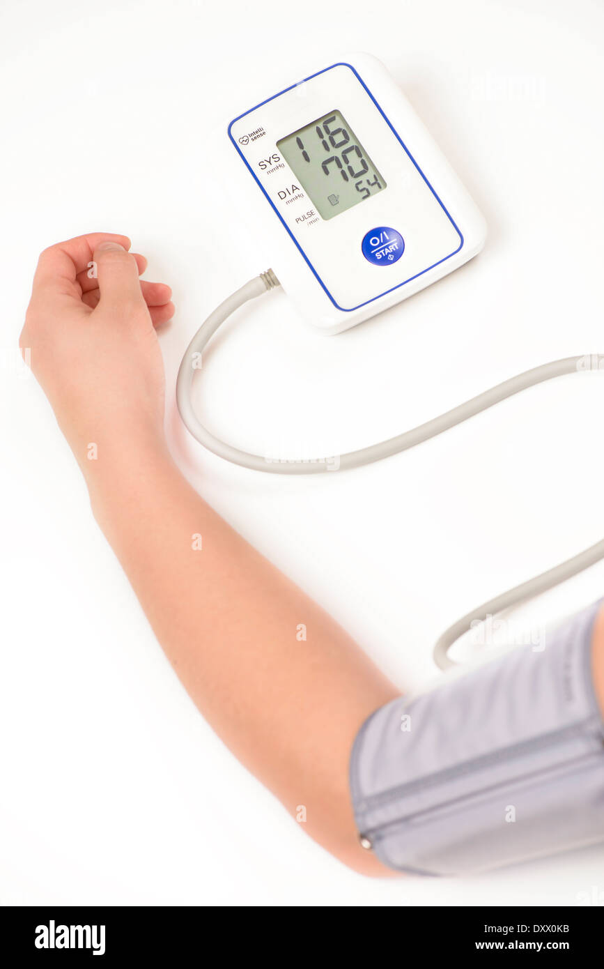 Donna misurando la propria pressione sanguigna Foto Stock