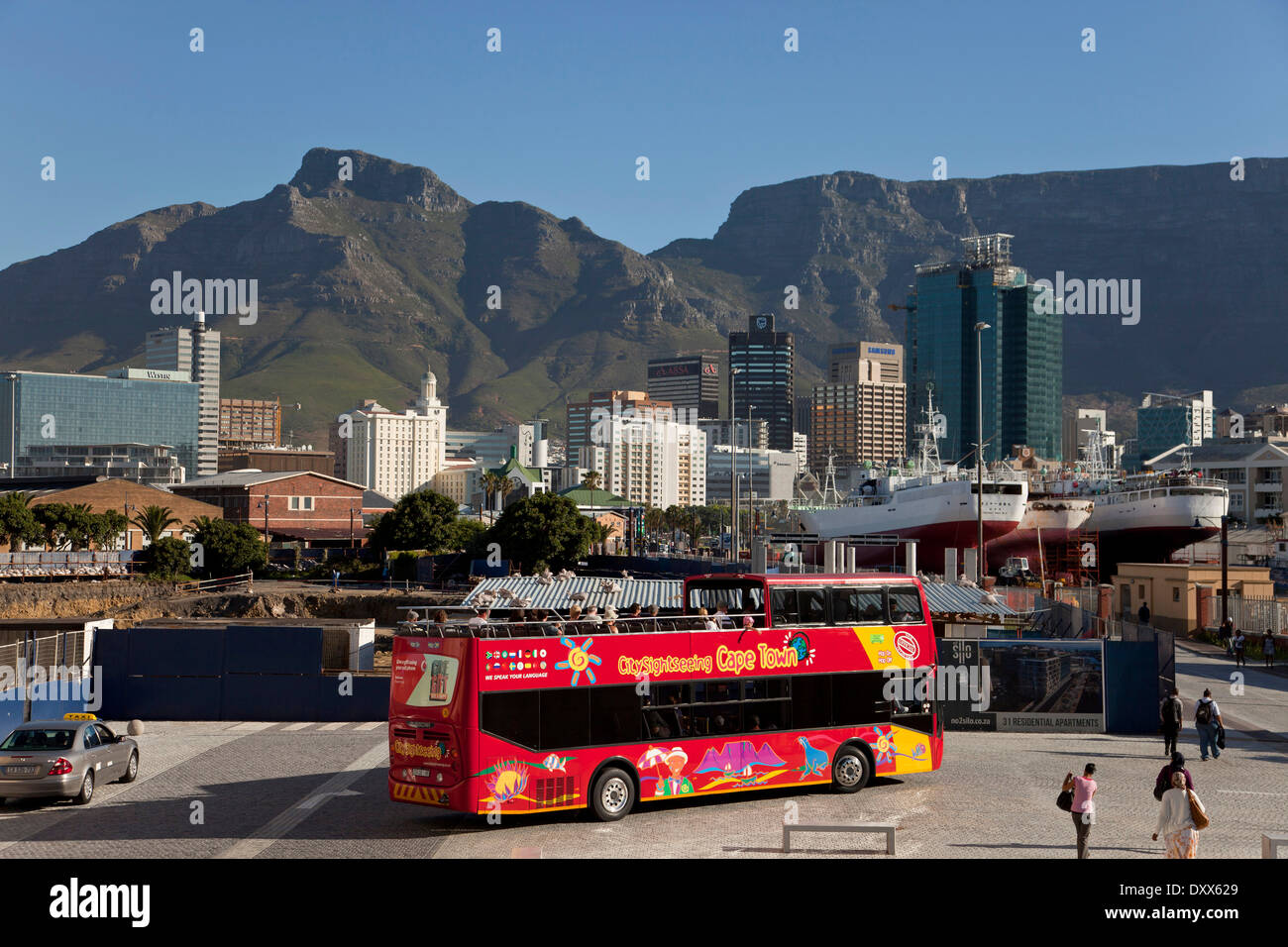 Bus rosso di City Sightseeing Cape Town e la skyline di Città del Capo, Western Cape, Sud Africa Foto Stock