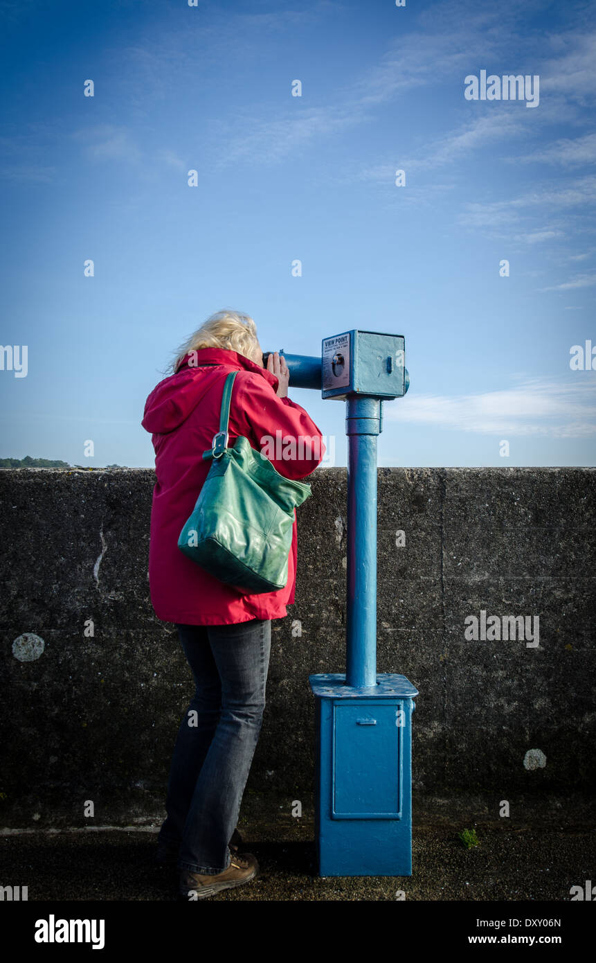 Donna che utilizza un pay per view telescopio Foto Stock