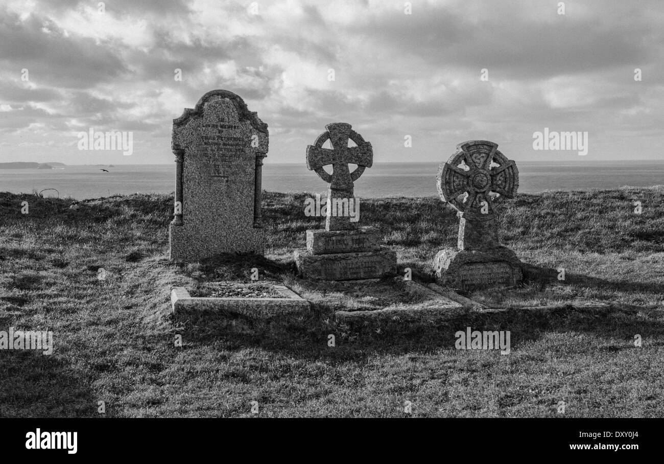 Tre in cima alla scogliera di tombe che si affaccia sul mare di Tintagel cantiere della chiesa Foto Stock