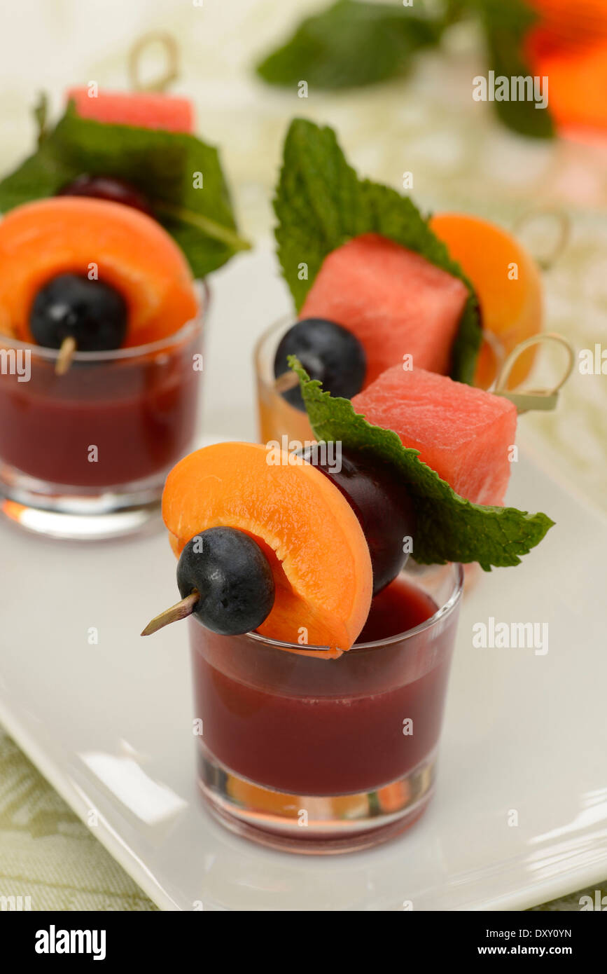 Succo di frutta con mini frutta fresca brochettes Foto Stock