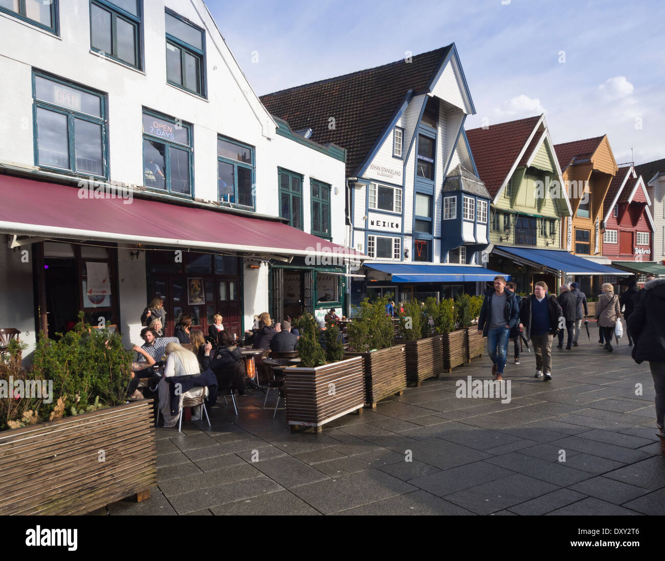 Ristoranti all'aperto in vecchi magazzini, le caffetterie e i bar attraggono visitatori ogni volta che il sole mette in un aspetto, Stavanger Norvegia Foto Stock
