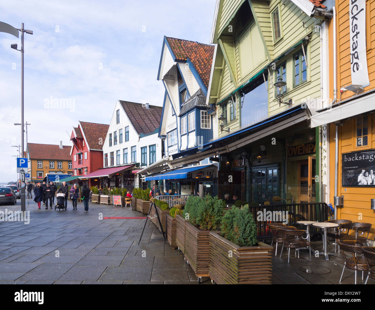 Ristoranti all'aperto in vecchi magazzini, le caffetterie e i bar attraggono visitatori ogni volta che il sole mette in un aspetto, Stavanger Norvegia Foto Stock
