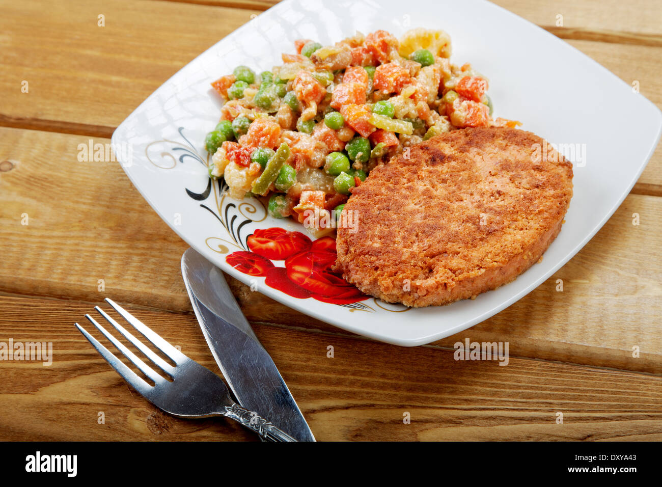 Cotoletta di pesce con una decorazione vegetale su un tavolo Foto Stock
