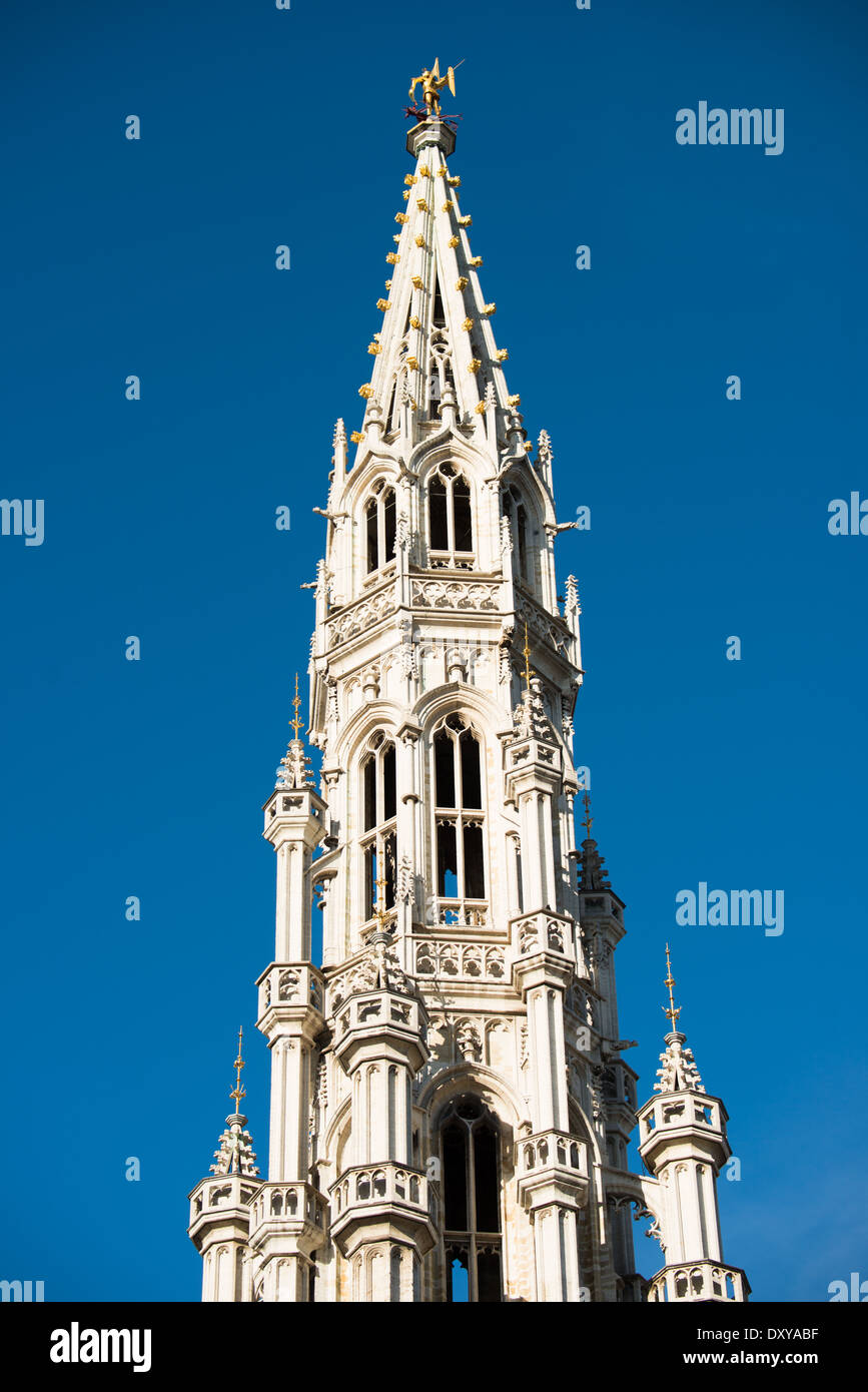 Municipio di Bruxelles guglie Bruxelles Belgio // BRUXELLES, Belgio - la guglia di 96 metri (315 piedi) del Municipio di Bruxelles domina lo skyline sopra la Grand Place. La torre gotica, completata nel XV secolo, è coronata da una statua dorata di San Michele, patrono di Bruxelles, che sconfigge un drago. Questo capolavoro medievale rappresenta l'apice dell'architettura gotica brabantina e rappresenta il punto di riferimento più riconoscibile della città. Foto Stock