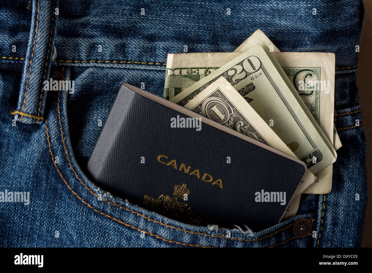 Blu jean pocket con passaporto canadese e USA valuta Foto Stock