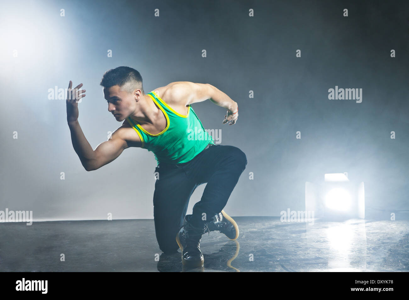 Stile moderno ballerina in posa su sfondo scuro con lampi e fumo Foto Stock