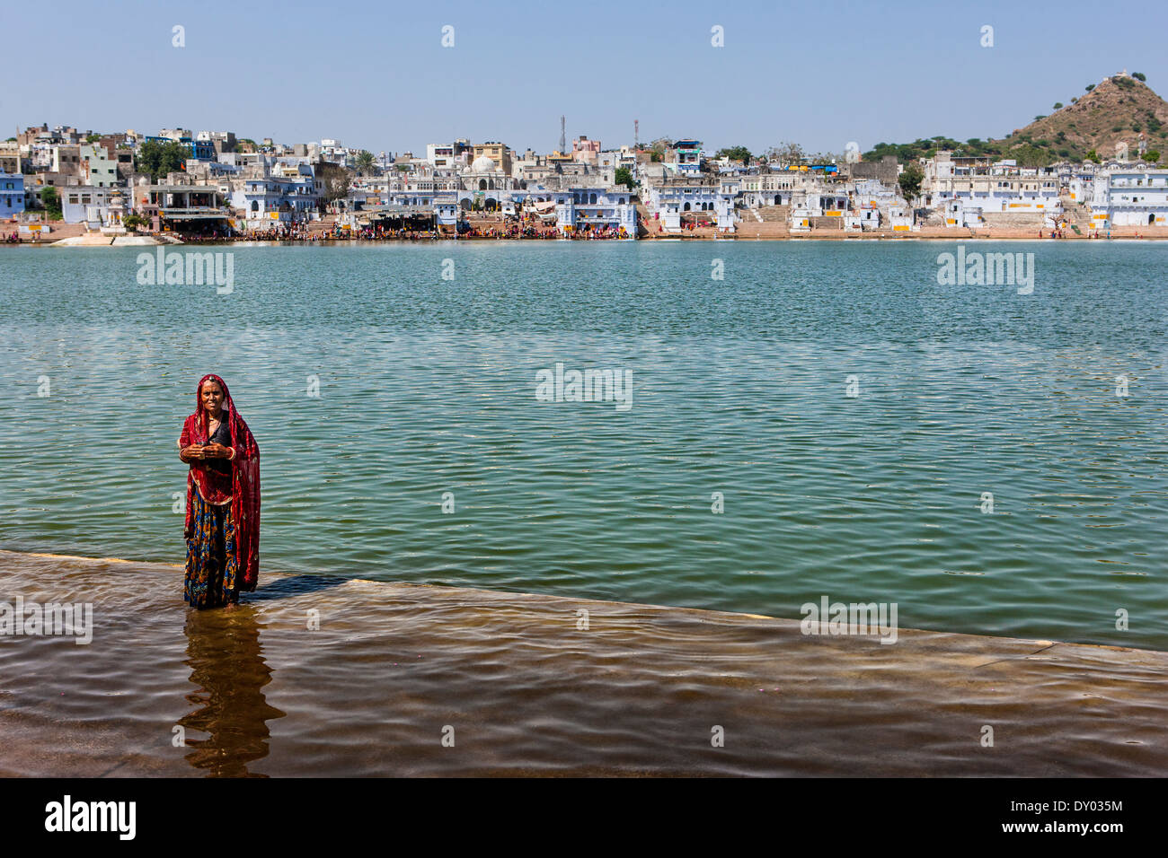 Donna indiana si erge su un lato lago in India Foto Stock