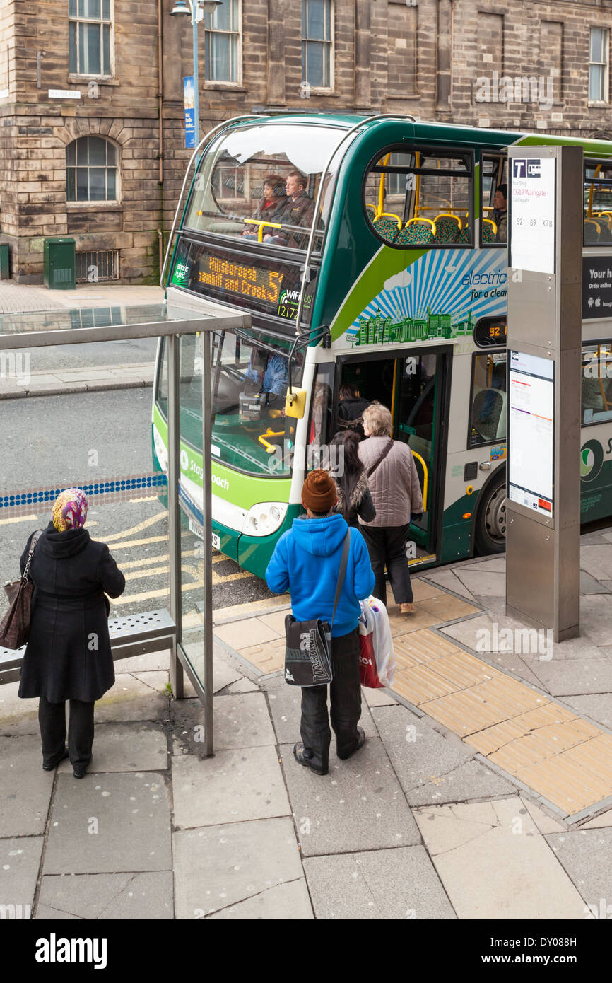 Regno Unito i mezzi di trasporto pubblici. Persone in piedi ad una fermata del bus mentre a salire su un autobus nel centro della città di Sheffield, South Yorkshire, Inghilterra, Regno Unito Foto Stock