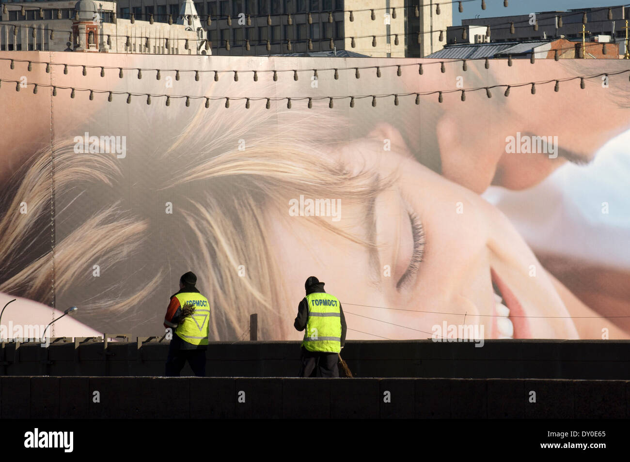 Pulitori comunale sulla Bolshoy Moskvoretskiy ponte contro un cartellone pubblicitario dello sfondo. Foto Stock