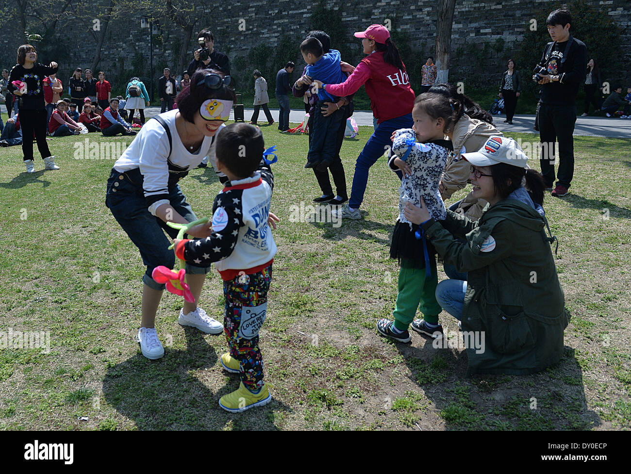 Nanjing, cinese della provincia di Jiangsu. 2 Apr 2014. I genitori e i loro bambini autistici giocare un gioco durante un bambino benessere evento in Nanjing, a est della capitale cinese della provincia di Jiangsu, 2 aprile 2014. Il caso di mercoledì è stato organizzato da un locale per i bambini del centro di formazione per contrassegnare il settimo mondiale autismo Giornata di sensibilizzazione. Gli organizzatori hanno tenuto una serie di attività interattive nelle speranze di elevare la preoccupazione sociale per i bambini con autismo. © Shen Peng/Xinhua/Alamy Live News Foto Stock